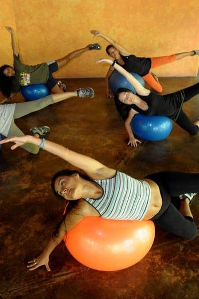 Side stretches over stability balls — a Pilates-with-elements session in full swing
