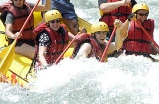 Rafting team running a drop on the Pacuare, virgin rainforest on both banks